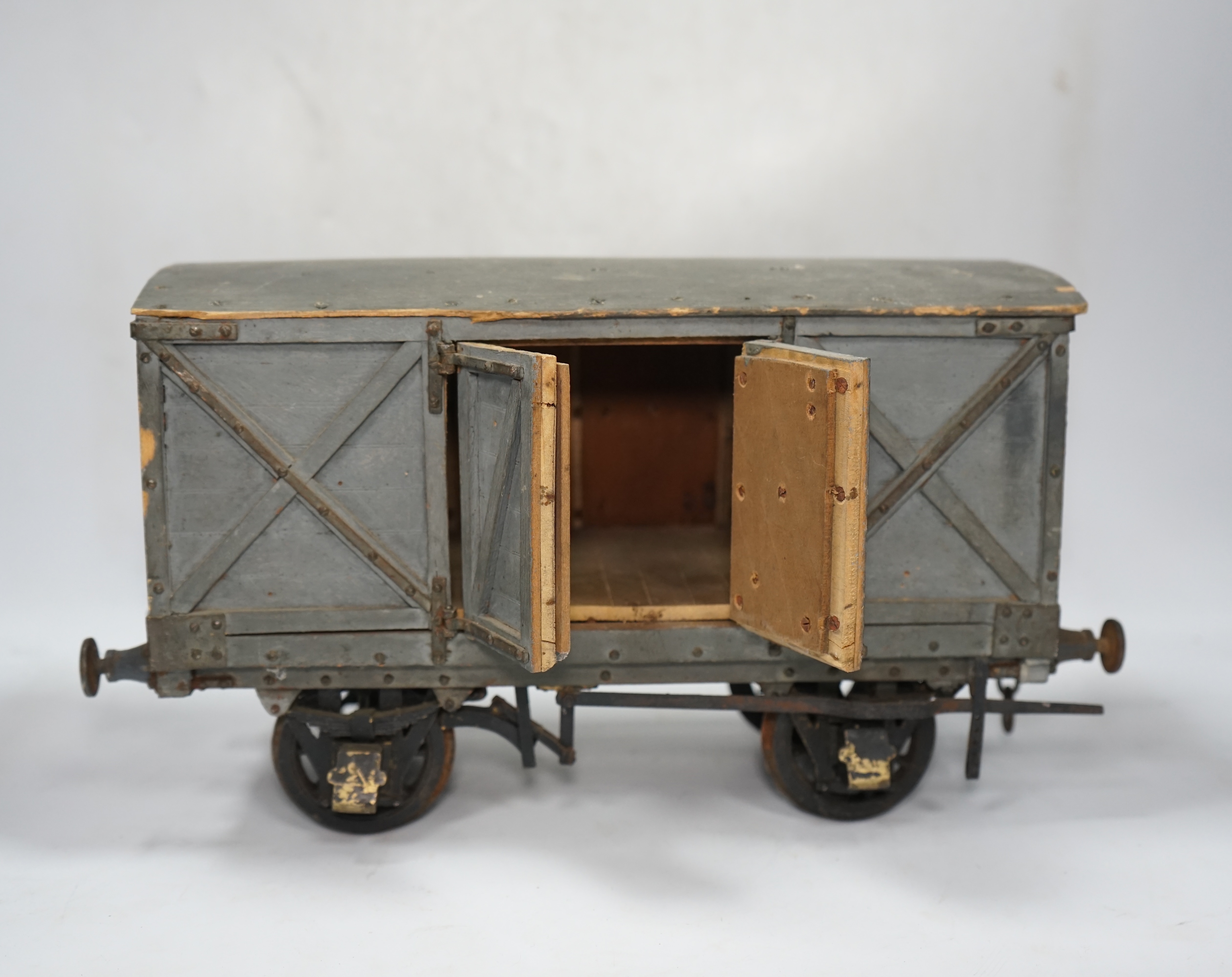 A 1950s/60s 3.5 inch gauge model railway box van, scratch built of plywood construction, with opening doors on both sides, 33cm long over the buffers, 18.5cm high. Condition - poor to fair, one buffer missing, springs mi